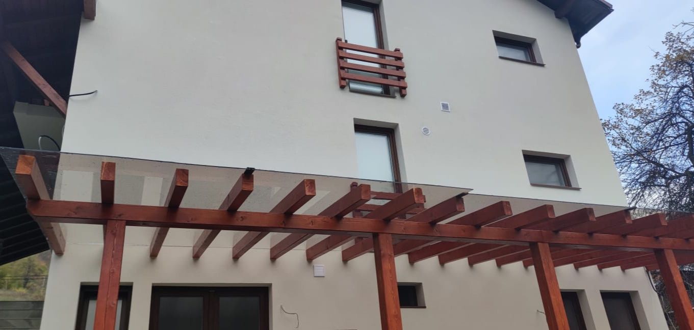Copertină cu structură de lemn și acoperiș din sticlă, montată pe o casă, Baia Mare