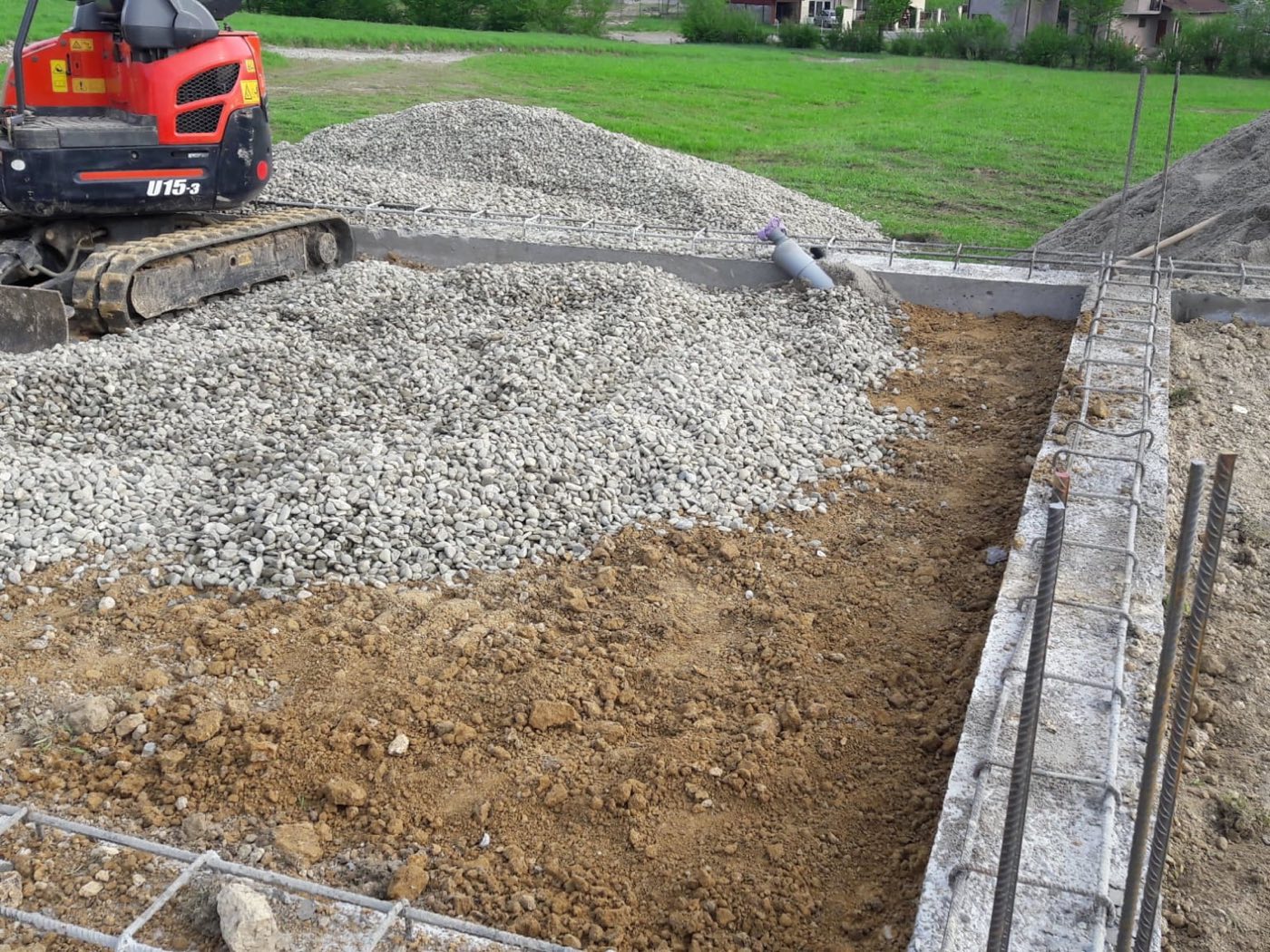 Miniexcavator care încarcă pietriș într-o fundație cu armătură, Baia Mare