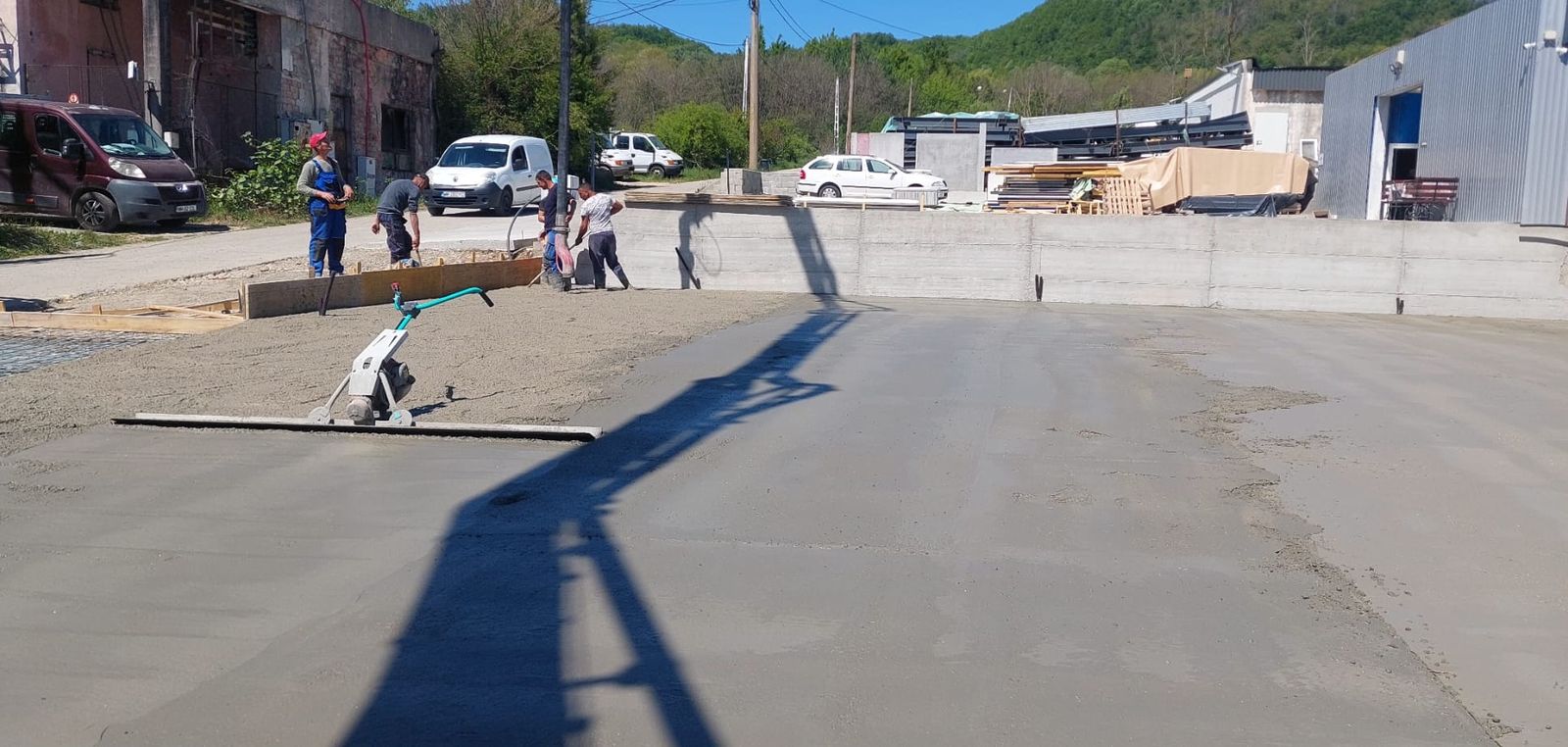 Muncitor care nivelează o platformă de beton cu mașina de driscuit, Maramureș