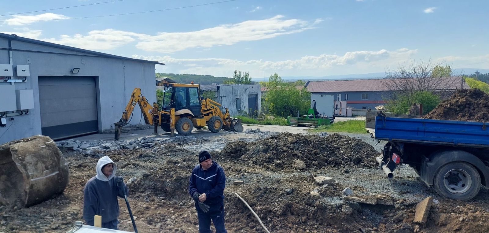Excavator care încarcă moloz într-un camion basculant