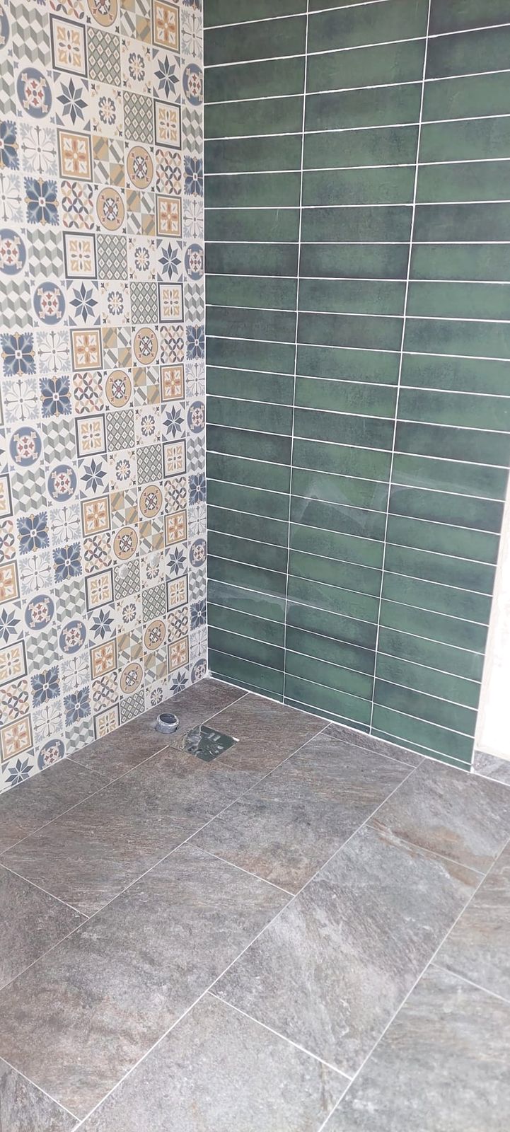 Baie renovată, cu faianță verde și plăci decorative patchwork